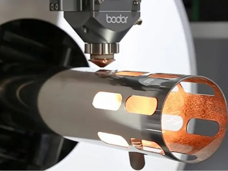 Laser cutting machine perforating a cylindrical metal tube